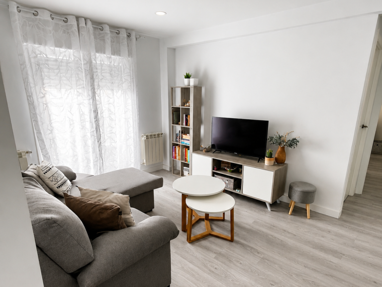 Salón reformado con zona de estar luminosa y suelo claro