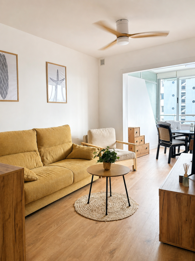 Salón reformado con mobiliario en tonos cálidos y suelo de madera